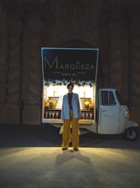 a man standing next to a food truck at night