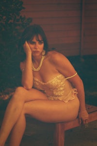 a woman sitting on a wooden bench